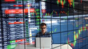 Man Sitting at a Computer with Charts